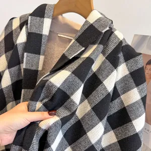 Macro detail of thick black and white plaid scarf fabric texture with wooden hanger