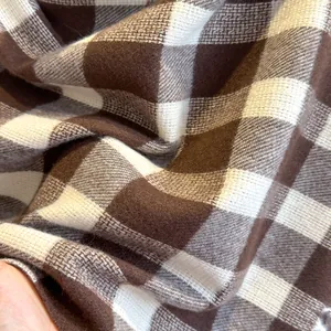 Macro shot of soft brushed brown and white plaid cashmere-like scarf fabric texture