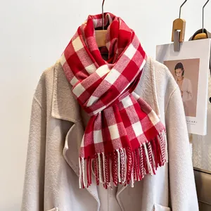 Detailed view of red and white plaid scarf with soft fringe on wool coat