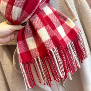 Detailed view of red and white plaid scarf with soft fringe texture for autumn winter