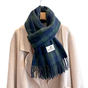 Classic blue and dark green plaid cashmere-like scarf with tassels on beige coat