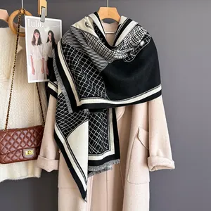 Detailed view of black and white geometric jacquard scarf with tassels and soft fabric texture
