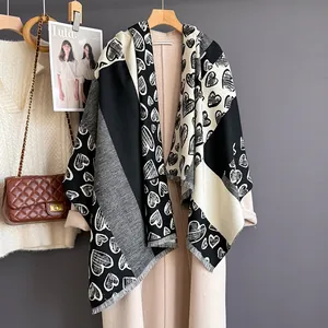 Close-up of black and white heart pattern cashmere scarf with fine fringe details