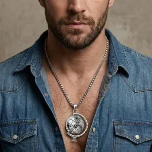 Men's silver spinning globe pendant necklace in stainless steel on a denim-clad model