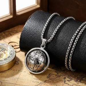 Rotating globe pendant on box chain displayed over a vintage nautical map and compass