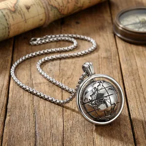 Macro shot of silver rotating globe pendant with box chain on a vintage nautical background