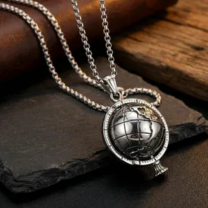 Detailed close-up of a silver spinning globe pendant on a black box chain