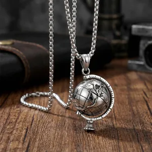 Detailed macro view of rotatable globe pendant with engraved continents on box chain