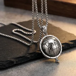 Detail of spinning stainless steel globe pendant with relief map on box chain