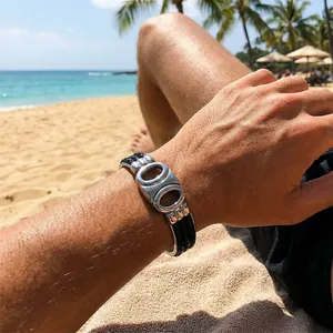 Nahaufnahme von geflochtenem Lederarmband für Herren mit Silberverschluss in Strandumgebung