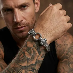 Close-up view of a vintage silver pig head braided steel bracelet on a tattooed wrist