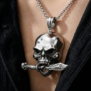 Close-up detail of a punk style skull pendant biting a dagger for men's fashion jewelry.