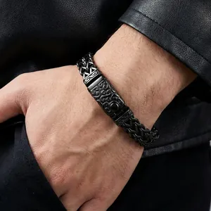 Macro shot of matte black stainless steel woven bracelet with engraved vintage metal plate