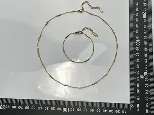 Dettaglio del set collana e bracciale in acciaio inossidabile dorato con scala