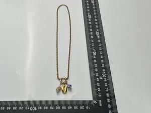Close-up of vintage gold necklace featuring blue and white porcelain beads and shell charms