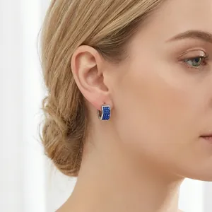 Elegant silver U-shaped hoop earrings with micro-paved blue zircons shown on a model