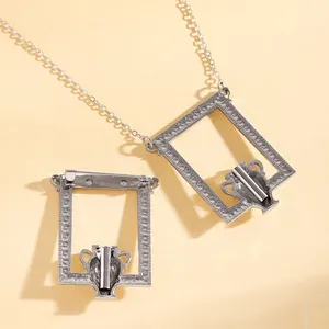 Makro-Detail der silbernen Brosche mit Vasenrelief und gehämmerter Metalloberfläche