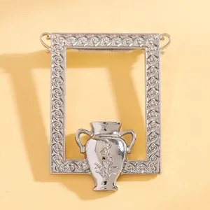 Detaillierte Nahaufnahme einer Vintage-Brosche mit geprägtem Silberrahmen und Blumen-Vase