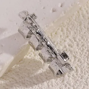 Detailansicht der Rückseite einer silbernen Brosche mit Hammerschlag-Textur