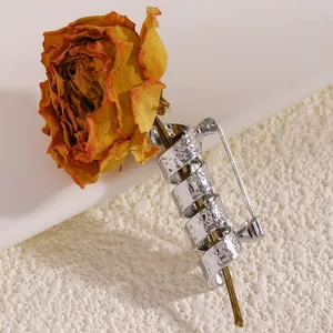 Detailansicht einer silbernen Spiralbrosche mit Hammerschlag-Optik und Trockenrose