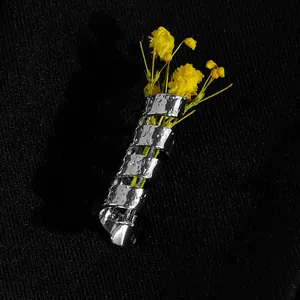 Detailansicht der silbernen Spiralkolben-Brosche mit Hammerschlag-Textur und Blumen