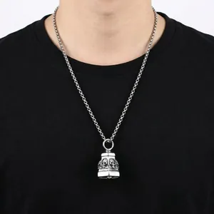Macro shot of punk style skull bell pendant with vintage oxidized finish on male model