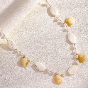 Detailansicht einer Taillenkette im Strandstil mit eleganten Perlen und Muschelanhängern.