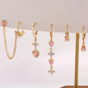 Set di 6 orecchini dorati con zirconi rosa a cuore e goccia su espositore per gioielli