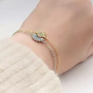 Detail of magnetic sun and moon bracelets with crystals on a beige knit sweater background