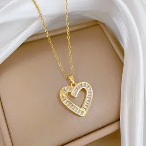 Detail of gold titanium heart necklace with rectangular baguette zircon on silk fabric