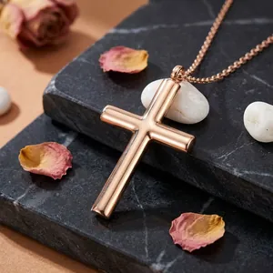 Dettaglio collana con croce in oro rosa su marmo nero con petali di rosa