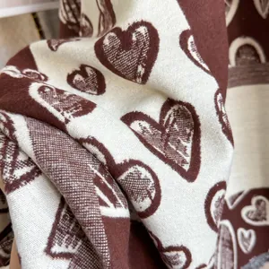 Close-up of heart pattern scarf fabric with thick cashmere-like knitting texture
