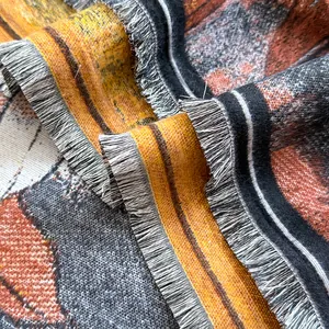 Dettaglio della sciarpa con motivo magnolia, frange e morbida trama effetto cashmere