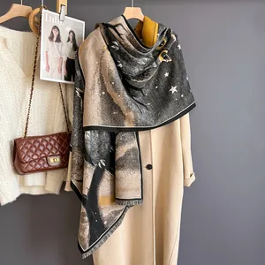 Detailed texture of owl print scarf with fringe edges paired with a beige winter coat