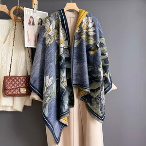 Dettaglio della sciarpa con stampa di magnolia e frange su un cappotto beige