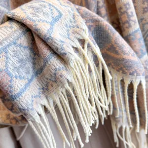Dettaglio della trama a quadri e delle frange morbide di una sciarpa spessa tipo cashmere