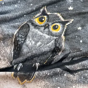 Close-up of owl print on cashmere-feel fabric with fine starry texture detailing