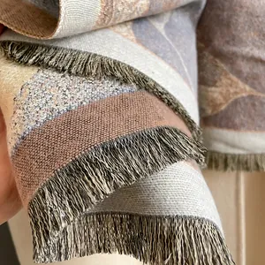 Detailopname van de dikke geweven sjaal met Morandi-patchwork en fijne franjeranden