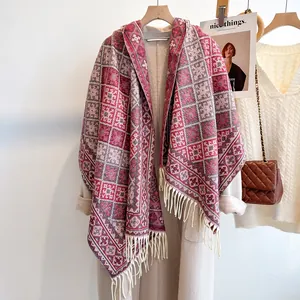 Sciarpa spessa a quadri con nappe drappeggiata su un cappotto invernale beige da donna