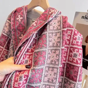 Dettaglio di sciarpa spessa a quadri rosa e grigi, consistenza morbida tipo cashmere