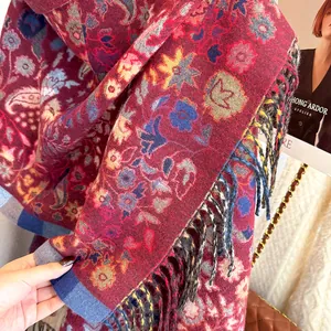 Detail of burgundy pashmina scarf with vintage floral patterns and fringe tassels