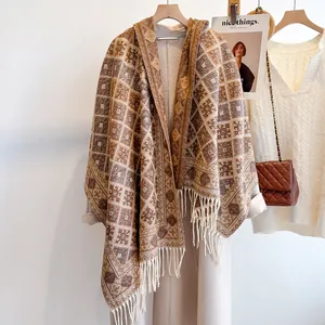 Dettaglio della mantella con cappuccio, motivo a rombi e bordi con frange sottili