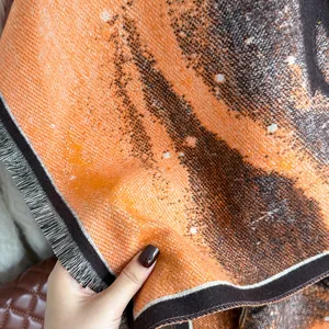 Detail of soft orange pashmina with abstract oil painting print and fine fringe edges