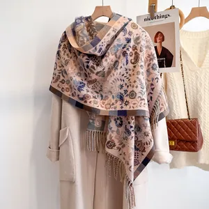 Bohemian paisley cashmere-feel scarf with tassels draped over a beige winter coat