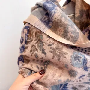 Close-up of paisley jacquard cashmere-feel scarf in beige, blue and tan tones