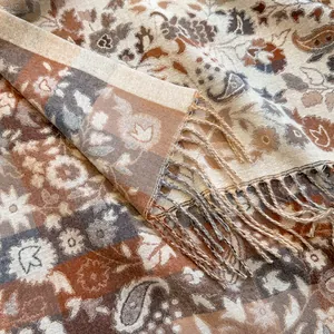 Close-up of thick winter scarf featuring vintage paisley floral patterns and fringe edges