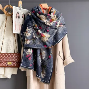 Close-up of navy scarf with magnolia floral print and retro fringe texture detail