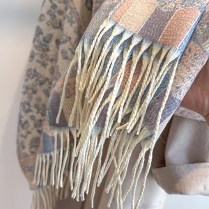 Detailed view of bohemian floral jacquard scarf featuring long soft cream fringe tassels