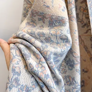 Close-up of thick floral cashmere-feel scarf showing soft texture and paisley patterns