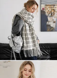 Detail of classic beige and black plaid scarf featuring long tassels and soft cashmere-like texture